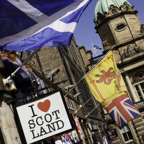 By i Storbritannia med flagg fra Skottland og Storbritannia. Bilde. 