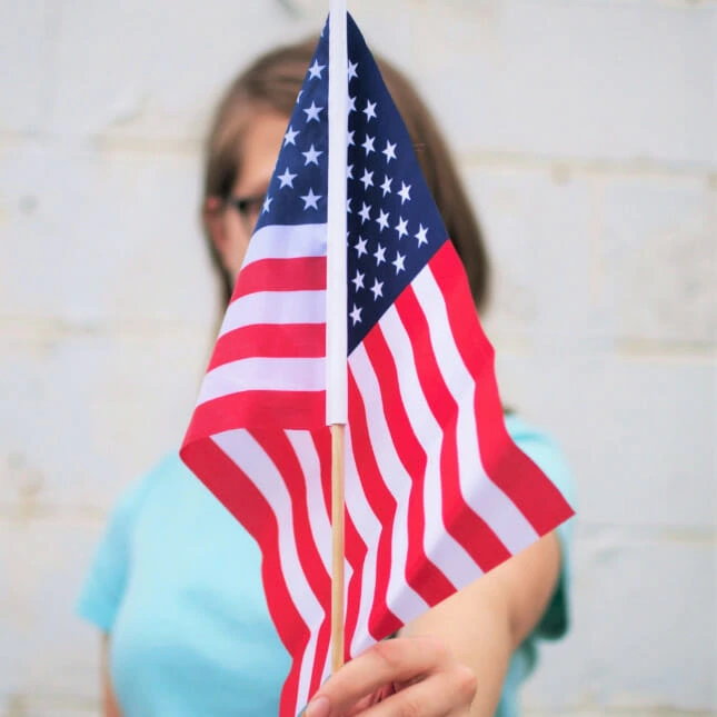 Student som holder oppe USA sitt flagg. Bilde