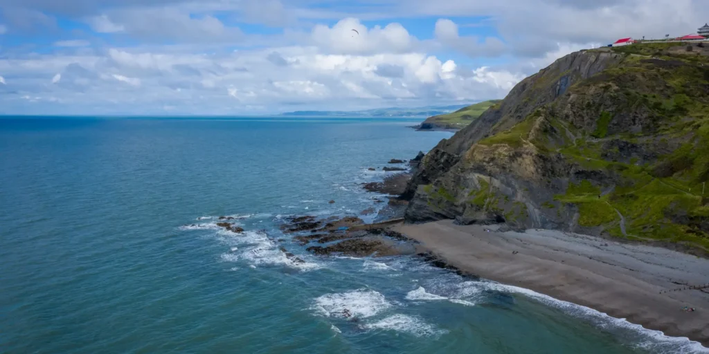 Bratte klipper og steinete strand ved Aberystwyth i Wales med utsikt mot havet.